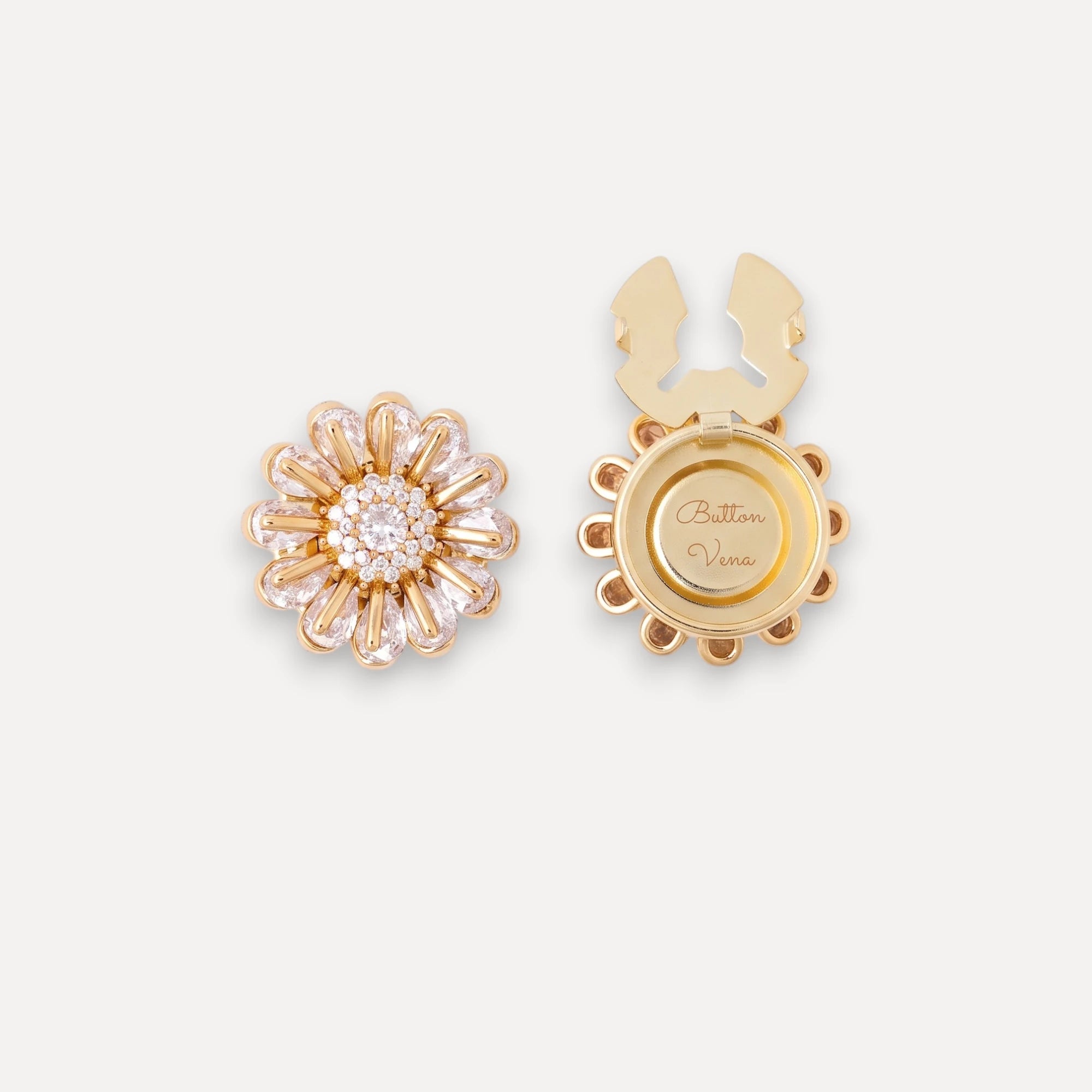 Bellis gold daisy clip-on button cover with hand-set cubic zirconia shown from both the front and back. The front features bellis design surrounding a round cluster of clear stones, while the back shows a circular gold plate engraved with 'Button Vena'.