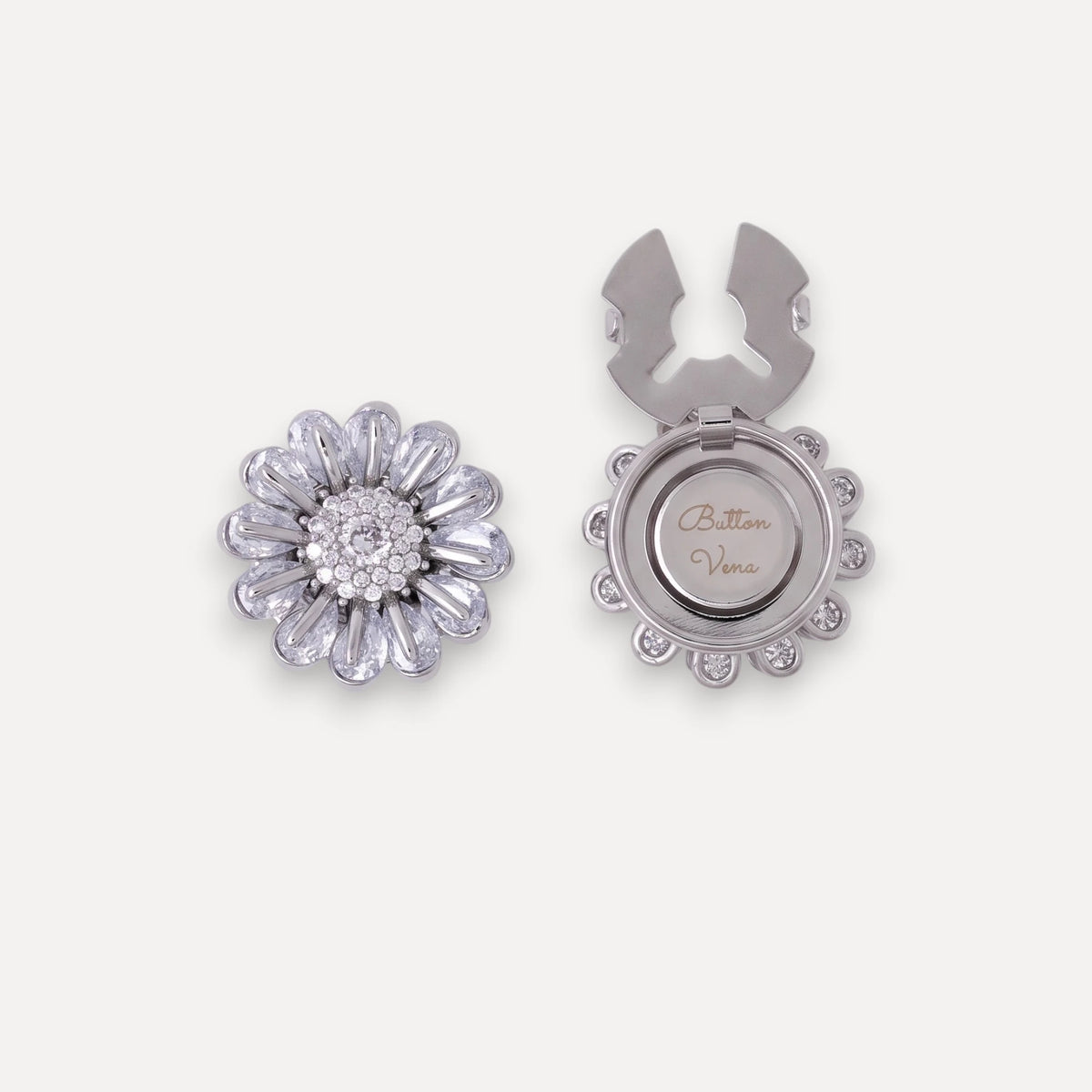 Bellis silver daisy clip-on button cover with hand-set cubic zirconia. The image shows both the front view of the buttonhole and the back view, which features a small circular compartment engraved with 'Button Vena'.