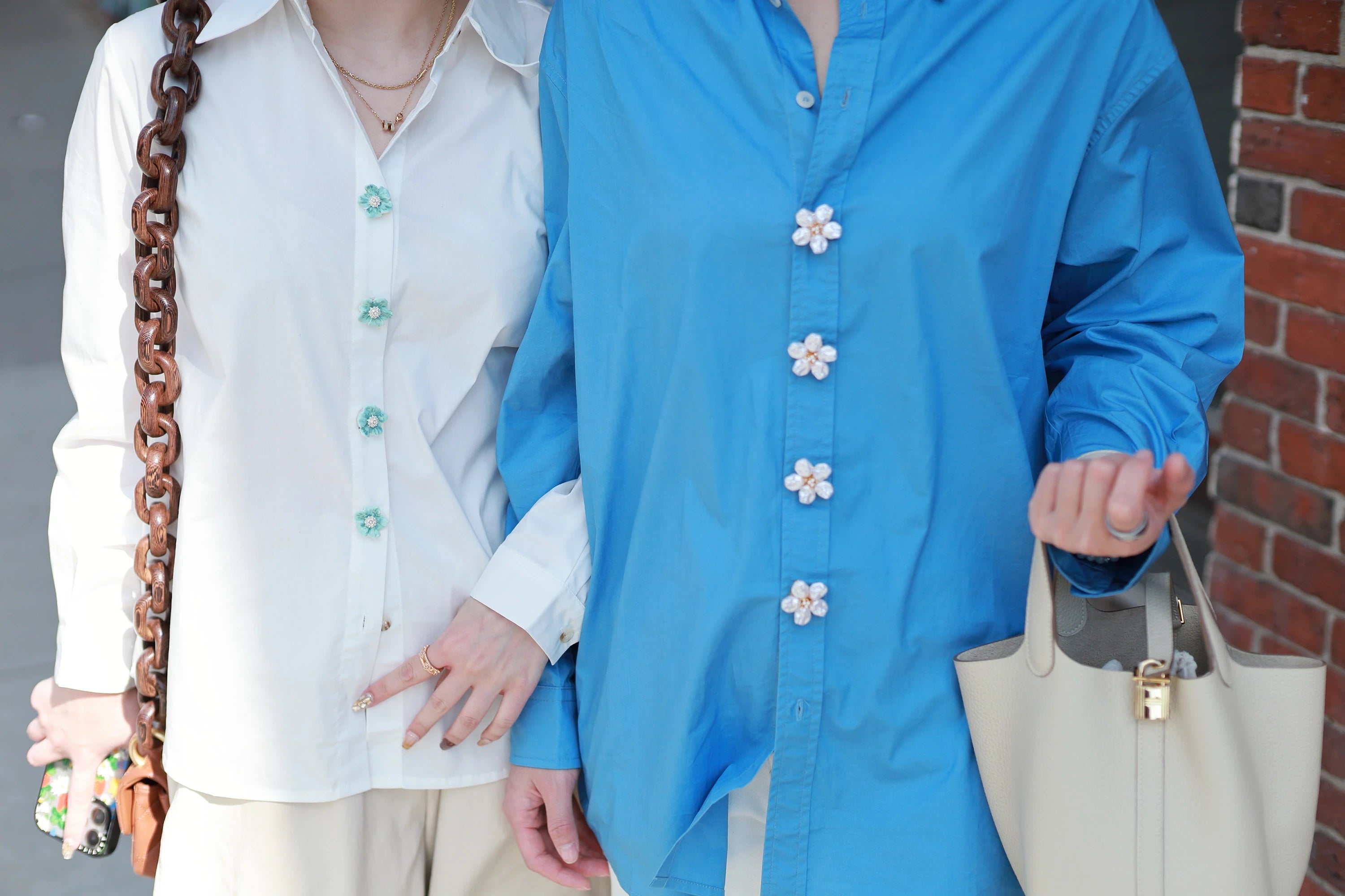 Button Vena Showcasing Button covers for shirts on Boston Street. one is wearing white shirt with Cerulean Dream silver button covers. Another one is wearing Blue shirt with Astral flora pearl button covers.