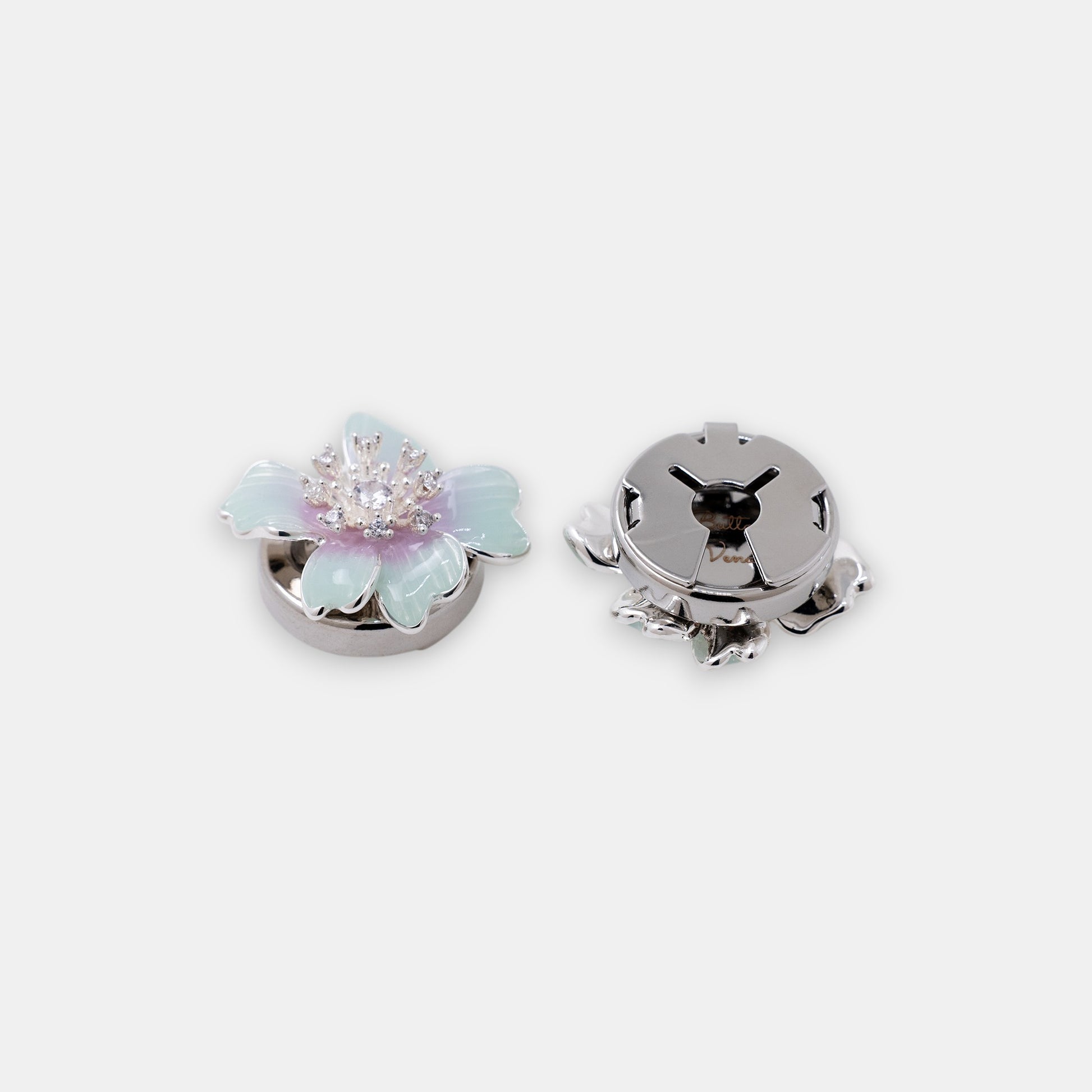 The Iris floral clip-on button cover with hand-painted teal and violet enamel and a brilliant zirconia center side