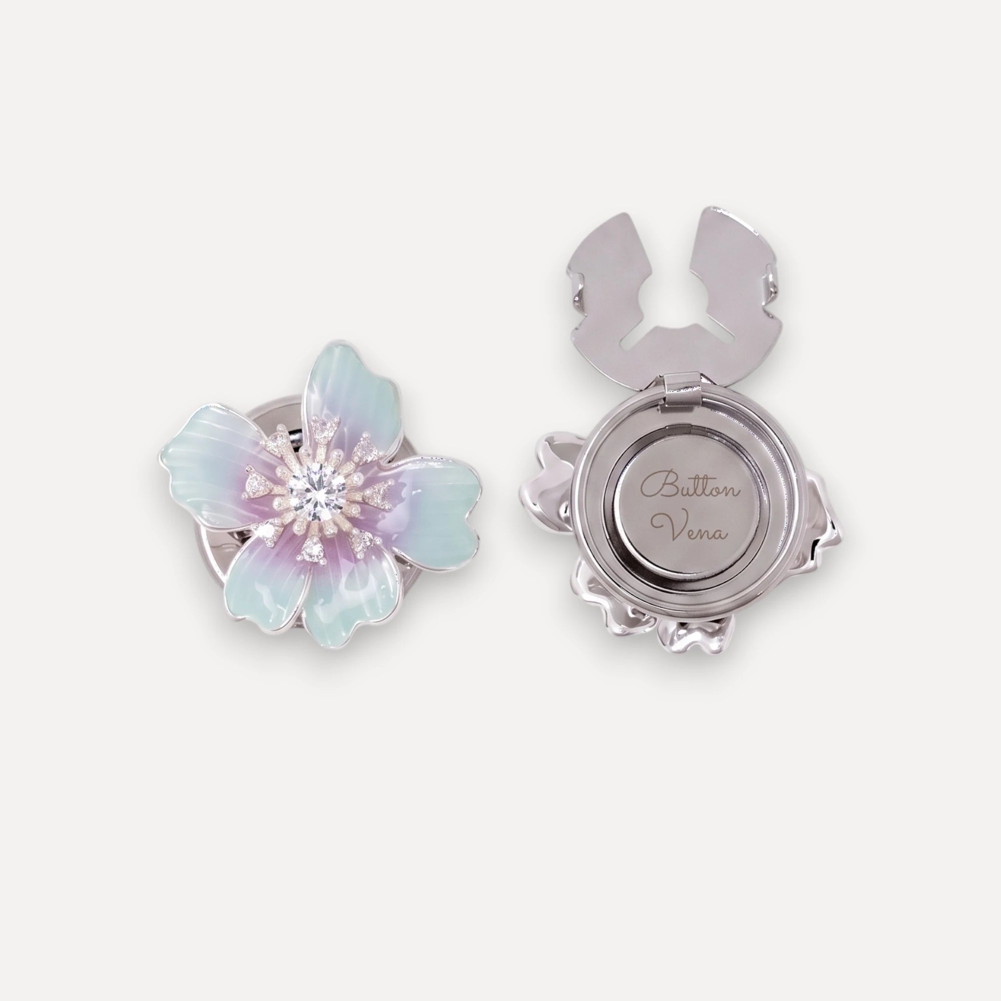 The Iris floral silver Plated clip-on button cover shown in both front and back views. The front features iridescent pastel blue and lavender petals with a sparkling clear crystal center.